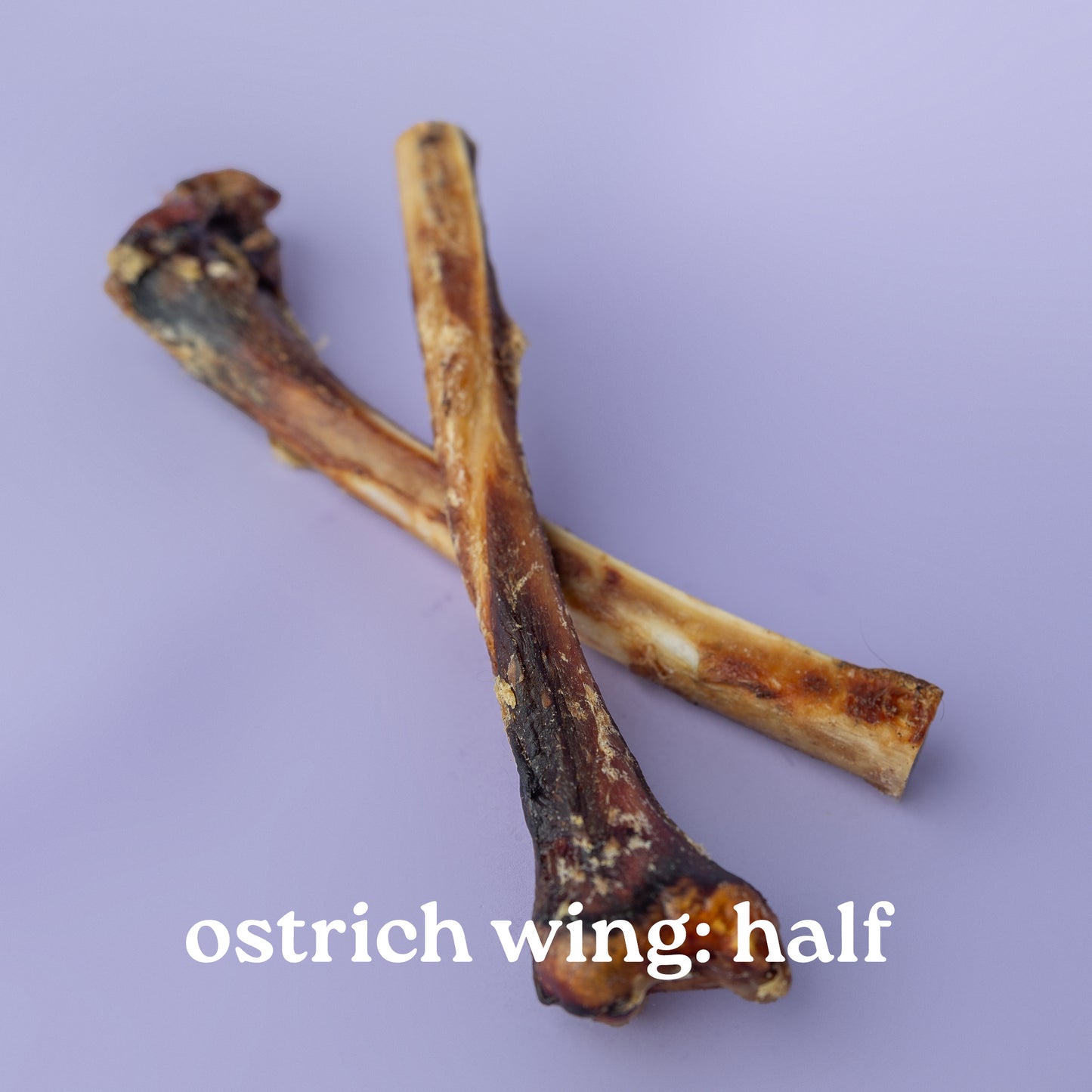 Two dried ostrich wings on a purple background with text 'ostrich wing: half'.