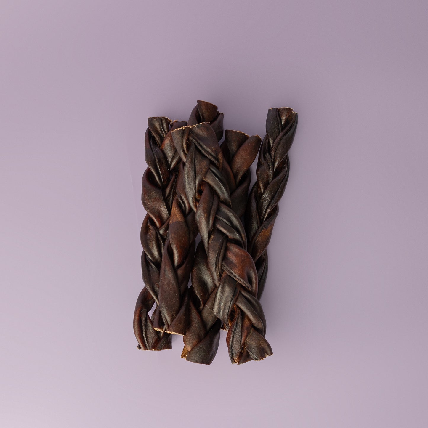 A beef collagen braid treat for dogs, displayed against a purple background, durable chew for dogs, bully stick alternative, low odor dog chew