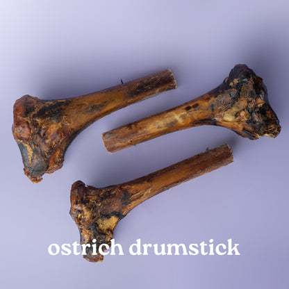 Three ostrich drumsticks on a purple background with 'ostrich drumstick' text.