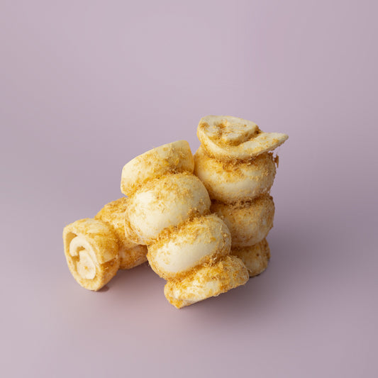 A bundle of rolled beef cheek dog chews, dusted with bully stick powder, against a purple background, rawhide alternative for dogs, beef cheek roll for dogs