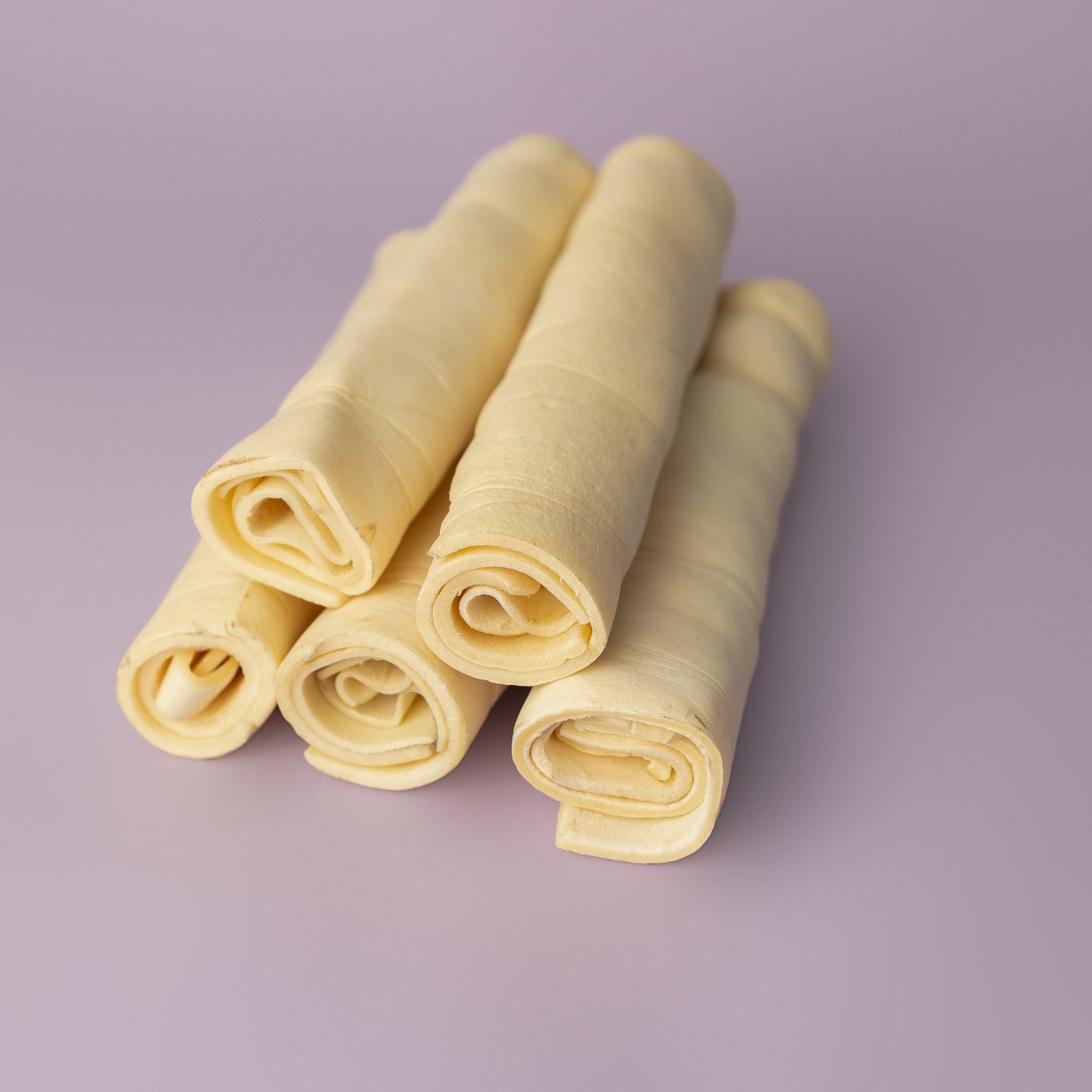 rawhide alternative, power chew for dogs, beef cheek roll for dogs, long lasting dog chew on purple background